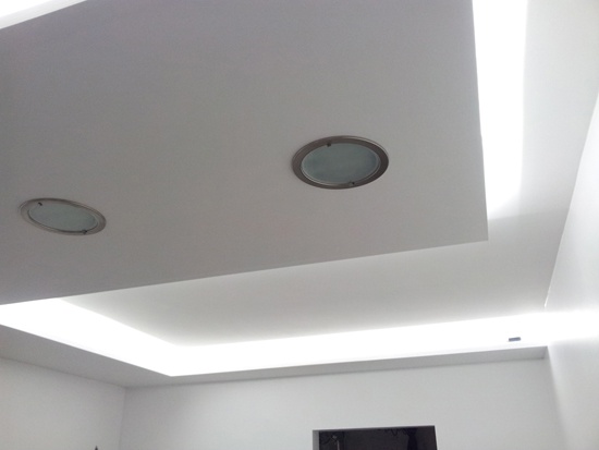 Des rubans de LED placés au dessus d'un ilot central de cuisine.